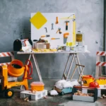 A playful arrangement of mini toy construction tools and accessories on a table indoors.