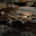 Close-up view of wrenches placed on a textured surface in a workshop setting.