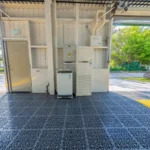 Spacious open garage with durable metal grid flooring and equipment setup facing outdoors.