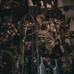 A cluttered auto workshop with various mechanical parts hanging in a dimly lit environment.