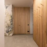 Elegant hallway interior featuring wooden panels and artistic wallpaper.