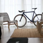 Cozy living room interior with a bicycle by the window, highlighting modern decor.