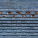 Close-up of a textured metal garage door with a unique brick-like pattern and weathered surface.