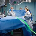 Surgeons in sterile gowns performing a medical operation