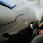 Detailed shot of a Lamborghini being polished, showcasing an automotive care process in a garage.