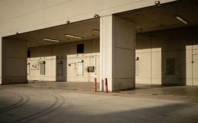 Empty industrial loading dock with sunlight casting shadows on walls.