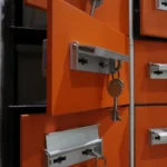 Orange lockers with metal keys highlighted in an indoor setting.
