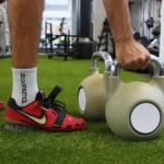 Athlete performing kettlebell workout in a modern gym setting.